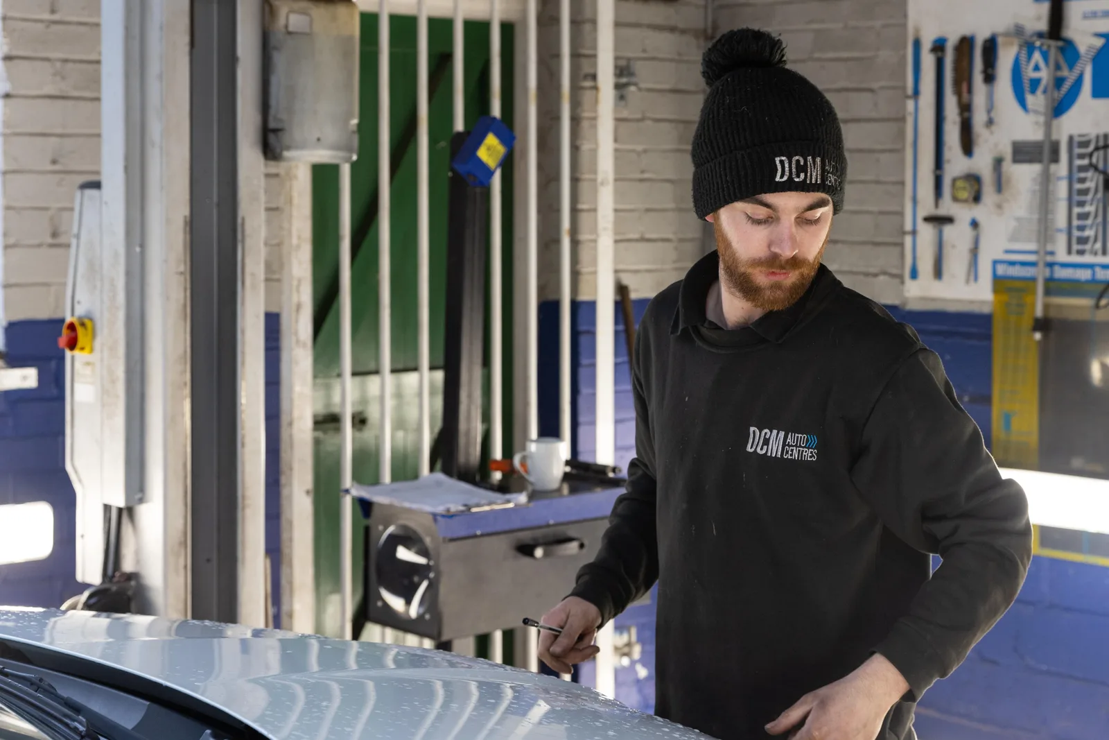DCM technician working under the bonnet of a car in the workshop
