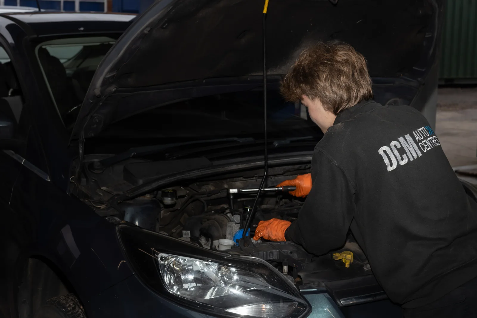 Technician checking the engine bay of a car